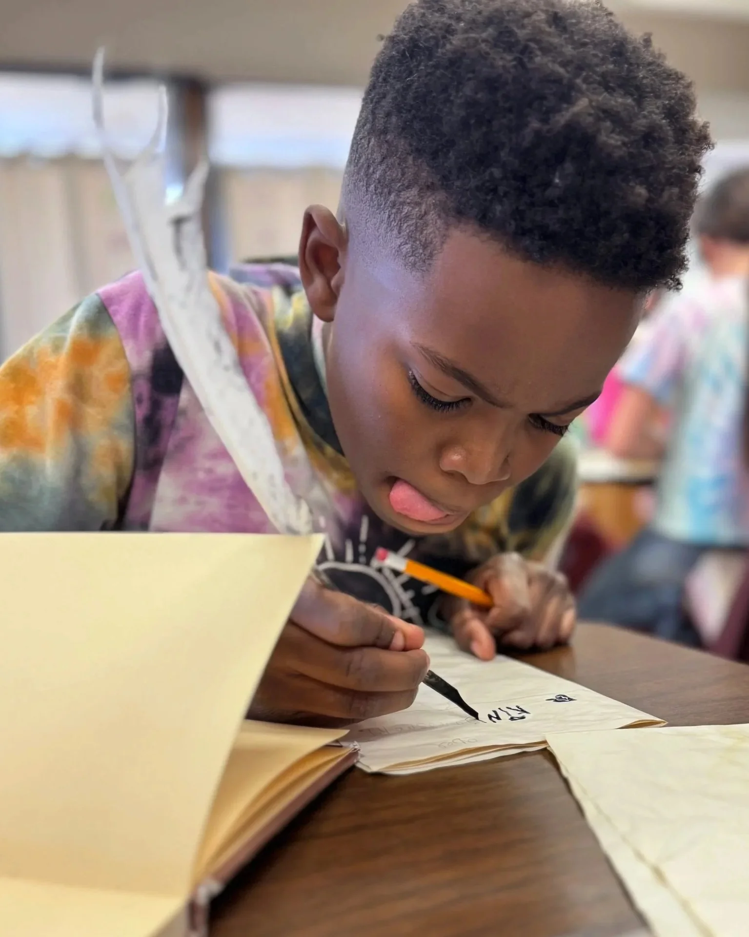 Student writing with a quill during a history lesson